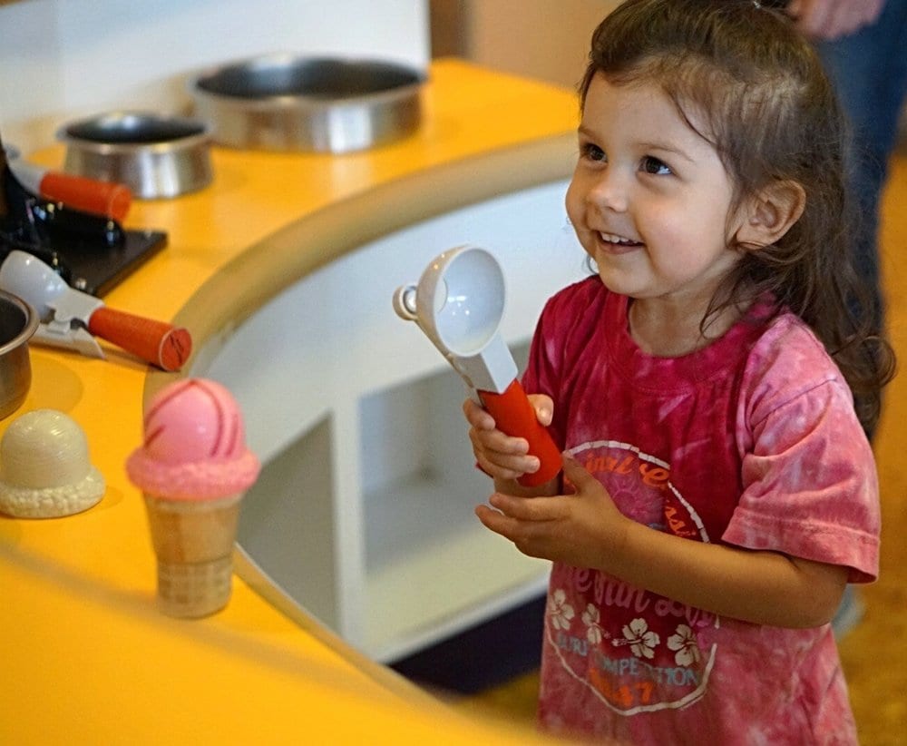 Child scooping play ice cream.